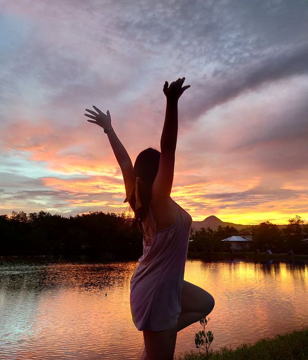 Silhouette of a person in a balancing yoga pose against a beautiful sunset.